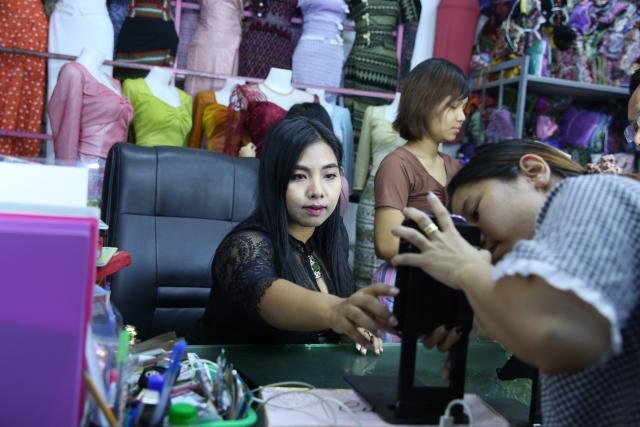 (251124) -- YANGON, Nov. 24, 2025 (Xinhua) -- A livestream seller prepares for a TikTok livestream in Yangon, Myanmar, Nov. 24, 2025. TO GO WITH "Feature: Myanmar's livestream sellers thrive in TikTok's booming marketplace" (Xinhua/Myo Kyaw Soe)