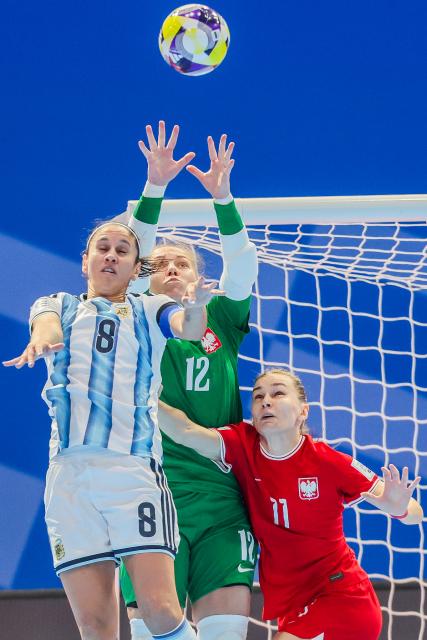 (251124) -- PASIG CITY, Nov. 24, 2025 (Xinhua) -- Karina Nunez (L) of Argentina competes against Natalia Majewska (C) and Wiktoria Pietrzyk of Poland during the group A match between Argentina and Poland at the FIFA Futsal Women's World Cup 2025 in Pasig City, the Philippines, Nov. 24, 2025. (Xinhua/Rouelle Umali)