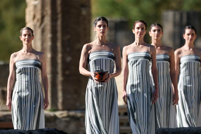 (251124) -- ANCIENT OLYMPIA, Nov. 24, 2025 (Xinhua) -- Actresses playing the role of ancient priestesses escort the urn during the dress rehearsal of the Olympic flame lighting ceremony for the Milan-Cortina 2026 Winter Olympic Games in Ancient Olympia, Greece, on Nov. 24, 2025. (Xinhua/Li Jing)