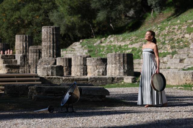(251124) -- ANCIENT OLYMPIA, Nov. 24, 2025 (Xinhua) -- An actress playing the role of ancient priestess performs during the dress rehearsal of the Olympic flame lighting ceremony for the Milan-Cortina 2026 Winter Olympic Games in Ancient Olympia, Greece, on Nov. 24, 2025. (Xinhua/Li Jing)