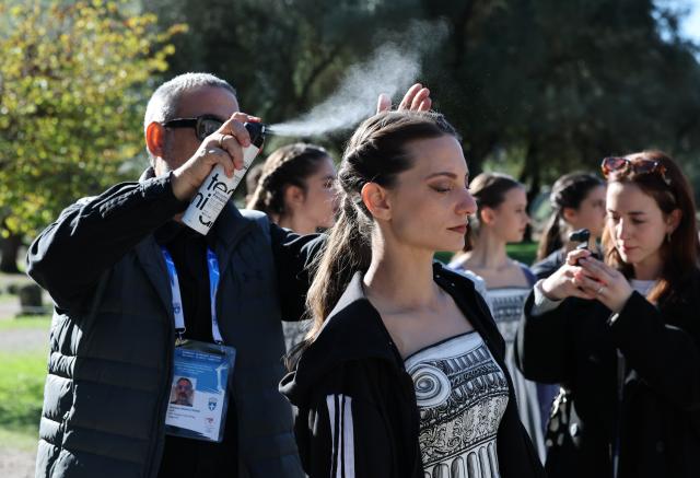 (251124) -- ANCIENT OLYMPIA, Nov. 24, 2025 (Xinhua) -- Actresses playing the role of ancient priestesses prepare for the dress rehearsal of the Olympic flame lighting ceremony for the Milan-Cortina 2026 Winter Olympic Games in Ancient Olympia, Greece, on Nov. 24, 2025. (Xinhua/Li Jing)