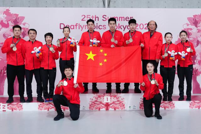 (251125) -- BEIJING, Nov. 25, 2025 (Xinhua) -- Members of China's men's and women's teams pose during the awarding ceremony after the men's team final of table tennis between China and Chinese Taipei at the 25th Summer Deaflympics Tokyo 2025 in Tokyo, Japan, Nov. 24, 2025. (Xinhua/Jia Haocheng)