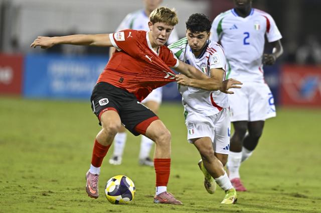 (251125) -- DOHA, Nov. 25, 2025 (Xinhua) -- Johannes Moser (L) of Austria vies with Vincenzo Prisco of Italy during the semifinal match between Austria and Italy at the FIFA U17 World Cup 2025 in Doha, Qatar, on Nov. 24, 2025. (Photo by Nikku/Xinhua)