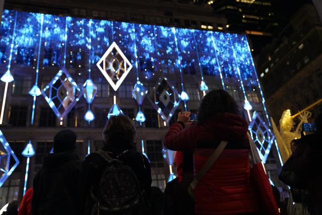 (251125) -- NEW YORK, Nov. 25, 2025 (Xinhua) -- People watch a light show in New York, the United States, Nov. 24, 2025. The Saks Fifth Avenue Holiday Light Show 2025 kicked off in New York City on Monday. (Xinhua/Zhang Fengguo)