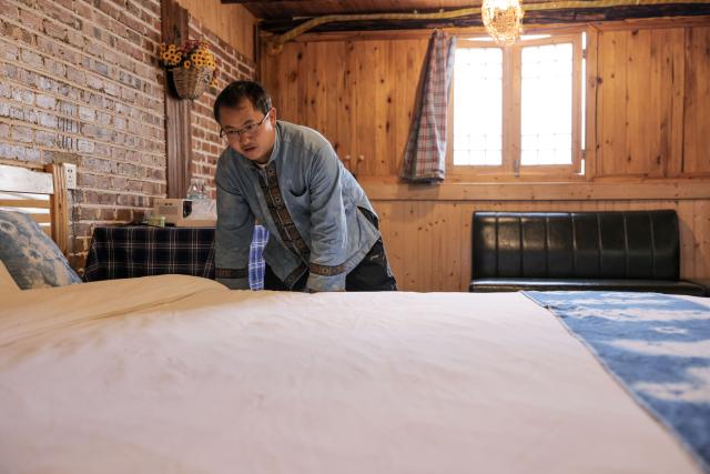 (251125) -- GUIYANG, Nov. 25, 2025 (Xinhua) -- An owner of a homestay tidies up a room at Pingjie Town of Bouyei-Miao Autonomous Prefecture of Qianxinan, southwest China's Guizhou Province, Nov. 6, 2025. The Huajiang Grand Canyon Bridge, soaring 625 meters above the Beipan River in Guizhou's mountainous terrain, is the world's highest bridge. The mega-project is also helping boost tourism in the nearby Pingjie Town, which has benefited from the improved traffic condition. (Xinhua/Ou Dongqu)