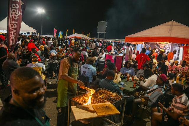 (251125) -- YAOUNDE, Nov. 25, 2025 (Xinhua) -- Visitors stroll through and enjoy themselves at the exhibition booths during the Cameroon International Music Festival in Buea, Cameroon, on Nov. 22, 2025. TO GO WITH "Feature: Melody as remedy -- Music festival eases conflict pains in Cameroon's troubled region" (Xinhua/Kepseu)