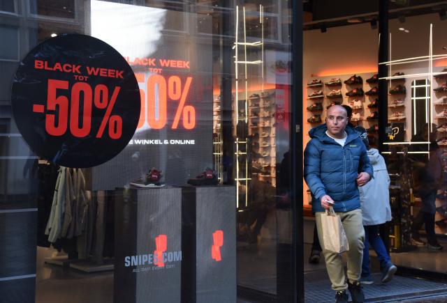 (251125) -- THE HAGUE, Nov. 25, 2025 (Xinhua) -- A man walks out a shop displaying Black Friday sales signs in the Hague, Netherlands, Nov. 25, 2025. (Xinhua/Shao Haijun)