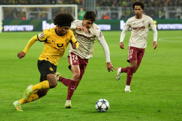 (251126) -- DORTMUND, Nov. 26, 2025 (Xinhua) -- Karim Adeyemi (L) of Borussia Dortmund vies with Sergi Cardona (C) of Villarreal CF during the UEFA Champions League group stage 5th round match between Borussia Dortmund and Villarreal CF in Dortmund, Germany, Nov. 25, 2025. (Photo by Joachim Bywaletz/Xinhua)
