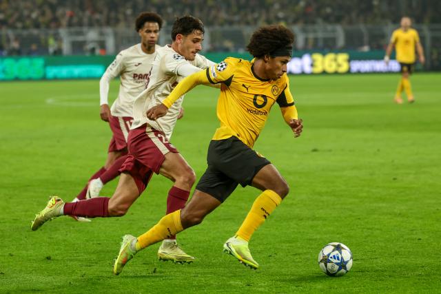 (251126) -- DORTMUND, Nov. 26, 2025 (Xinhua) -- Karim Adeyemi (R) of Borussia Dortmund vies with Sergi Cardona (C) of Villarreal CF during the UEFA Champions League group stage 5th round match between Borussia Dortmund and Villarreal CF in Dortmund, Germany, Nov. 25, 2025. (Photo by Joachim Bywaletz/Xinhua)