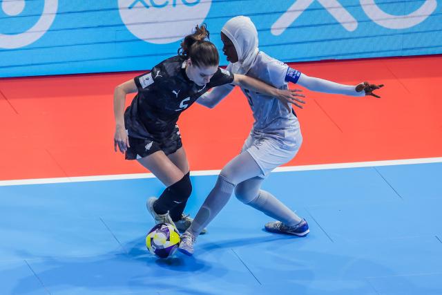 (251126) -- PASIG CITY, Nov. 26, 2025 (Xinhua) -- Fatuma Issa (R) of Tanzania competes against Sophie Williams (L) of New Zealand during the group C match between New Zealand and Tanzania at the FIFA Futsal Women's World Cup 2025 in Pasig City, the Philippines, Nov. 26, 2025. (Xinhua/Rouelle Umali)