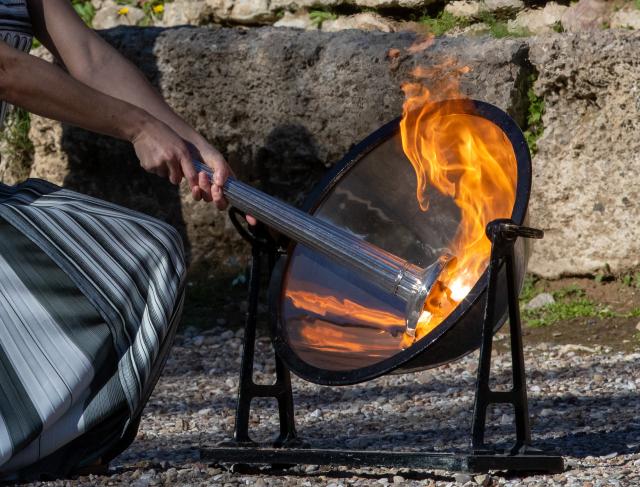 (251126) -- ANCIENT OLYMPIA, Nov. 26, 2025 (Xinhua) -- Actress Mary Mina, in the role of an ancient Greek High Priestess, lights the flame during the dress rehearsal of the Olympic flame lighting ceremony for the Milan-Cortina 2026 Winter Olympic Games in Ancient Olympia, Greece, on Nov. 24, 2025. (Photo by Marios Lolos/Xinhua)