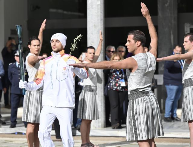 (251126) -- ANCIENT OLYMPIA, Nov. 26, 2025 (Xinhua) -- The first torchbearer, Greek rower Petros Gkaidatzis (L, front) carries the torch during the torch relay after the Olympic flame lighting ceremony for the Milan-Cortina 2026 Winter Olympic Games in Ancient Olympia, Greece, on Nov. 26, 2025. (Xinhua/Lyu You)