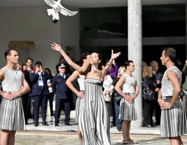 (251126) -- ANCIENT OLYMPIA, Nov. 26, 2025 (Xinhua) -- A performer releases a dove during the Olympic flame lighting ceremony for the Milan-Cortina 2026 Winter Olympic Games in Ancient Olympia, Greece, on Nov. 26, 2025. (Xinhua/Lyu You)
