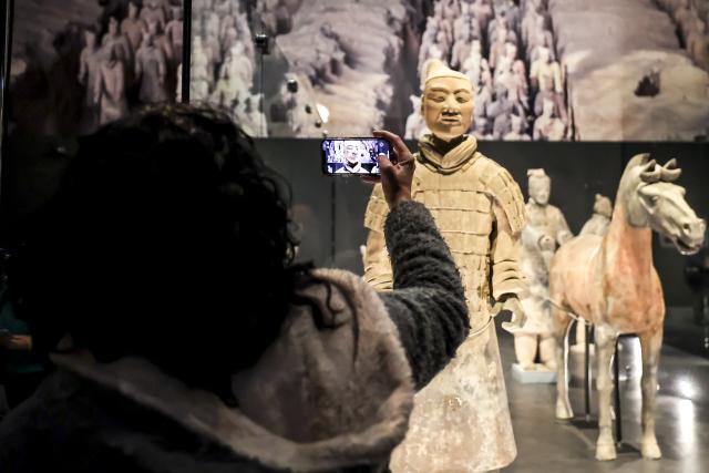 (251126) -- BUDAPEST, Nov. 26, 2025 (Xinhua) -- A visitor takes photos of exhibits during the media preview of the exhibition "The Civilization of the Qin and Han Dynasties -- The First Chinese Emperor's Terracotta Warriors" at the Museum of Fine Arts in Budapest, Hungary on Nov. 26, 2025. (Photo by David Balogh/Xinhua)