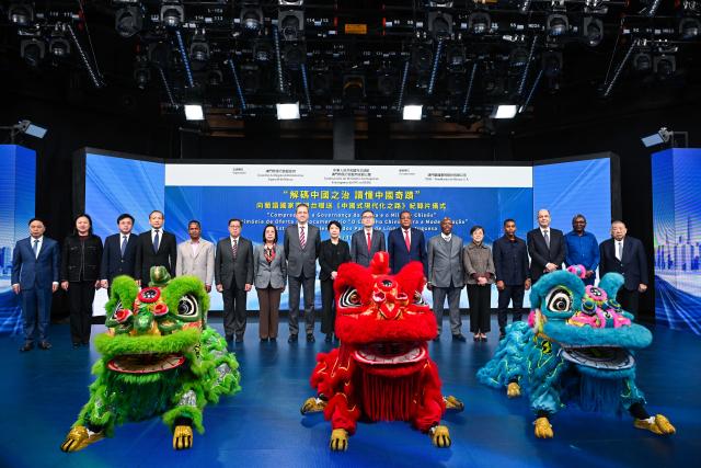 (251127) -- MACAO, Nov. 27, 2025 (Xinhua) -- Guests pose for a group photo during a ceremony to present a documentary on Chinese modernization to Portuguese-speaking countries' television networks in Macao, south China, Nov. 26, 2025. TO GO WITH "Commissioner's office of Chinese Foreign Ministry in Macao SAR presents documentary to Portuguese-speaking broadcasters" (Xinhua)