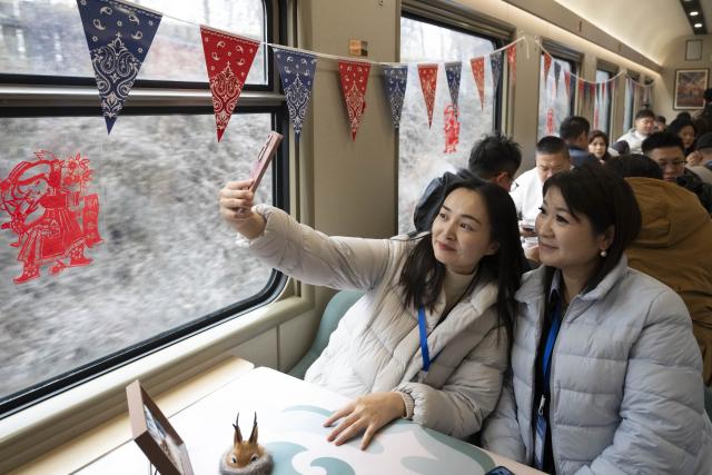 (251127) -- BEIJING, Nov. 27, 2025 (Xinhua) -- Passengers take photos onboard the Train Y783 on Nov. 26, 2025. Train Y783, an ice-and-snow themed tourism train, was launched at Harbin Railway Station and started a six-day trip on Wednesday. (Xinhua/Zhang Tao)