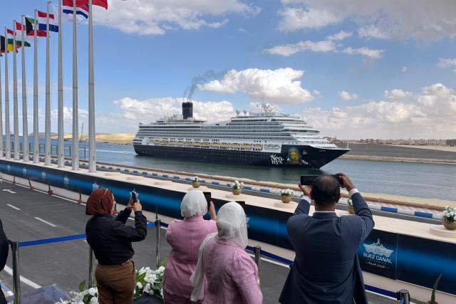 (251127) -- BEIJING, Nov. 27, 2025 (Xinhua) -- People take photos of a ship transiting the Suez Canal in Ismailia Governorate, Egypt, on Nov. 25, 2025. Egypt's Suez Canal Authority (SCA) and Danish shipping and logistics company Maersk signed here on Tuesday a strategic partnership agreement, signaling the latter's potential return to the Red Sea route via the Suez Canal after a nearly two-year suspension. (Xinhua/Ahmed Gomaa)