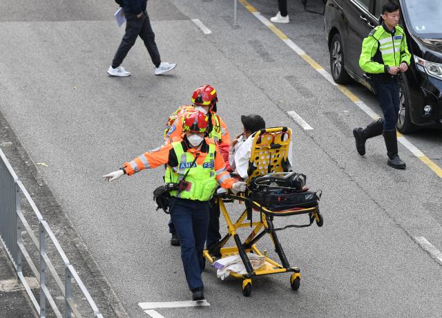 (251127) -- HONG KONG, Nov. 27, 2025 (Xinhua) -- Rescuers transfer an injured person at a residential area fire site in Hong Kong, south China, Nov. 27, 2025. Three men have been arrested for suspected manslaughter in a fire that broke out in Wang Fuk Court, a residential area in Tai Po of Hong Kong, on Wednesday afternoon, the Hong Kong Police Force said at the press briefing on Thursday.
   The fire had left 44 people dead and 45 others injured by early Thursday morning, the police said. (Xinhua/Chen Duo)