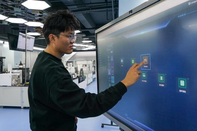 (251127) -- HEFEI, Nov. 27, 2025 (Xinhua) -- Doctoral student Guo Lulu instructs an experiment via an intelligent platform at the state key laboratory of precision and intelligent chemistry of the University of Science and Technology of China (USTC) in Hefei, east China's Anhui Province, Nov. 24, 2025. Traditional chemical research has long relied on continuous trial and error by scientists. With the development of artificial intelligence and robotic automation technologies, it has become possible to design experiments and issue instructions through intelligent platforms, using robots to replace human labor in experiential operations, which enhances experimental efficiency and precision. 
   In 2021, after eight years of dedicated effort by a research team from USTC, Xiaolai, the first-generation "robot chemist," was successfully developed. After several years of iterations, the second-generation dual-armed humanoid robot Xiaolin has been put into operation, capable of performing more complex tasks. It has evolved from a substitute of human labor to a "research partner."
   According to Zhu Zhuoying, a professor from the state key laboratory of precision and intelligent chemistry at USTC, the team's ultimate goal is to enable robots to achieve fully autonomous scientific research. In the future, they might identify entirely new research directions by "reading" literature themselves and achieve breakthroughs in areas beyond human exploration. (Xinhua/Du Yu)