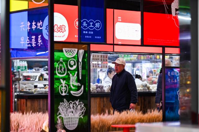 (251127) -- TIANJIN, Nov. 27, 2025 (Xinhua) -- People shop at Sanshui grocery market in Hexi District of Tianjin, north China, Nov. 25, 2025. With reading room, coffee outlet and grocery stalls brought under the same roof, Sanshui market, a traditional shopping place of more than 20 years old, was given a new life when it went through a refurbishing project and opened to business again in September this year. 
   Thanks to the newly added scenarios, Sanshui is no longer a mere source of daily necessities to the over 30,000 residents in 13 surrounding communities, but also a space to spend their leisure time in.
   The renewal of this grocery market is just one of the many vivid examples of Hexi District's efforts to improve amenities for the local residents. To date, the district is home to 46 "15-minute circles of daily convenience," where local residents are able to meet their daily needs within a 5-minute walk and access quality services within a 15-minute walk. (Xinhua/Zhao Zishuo)