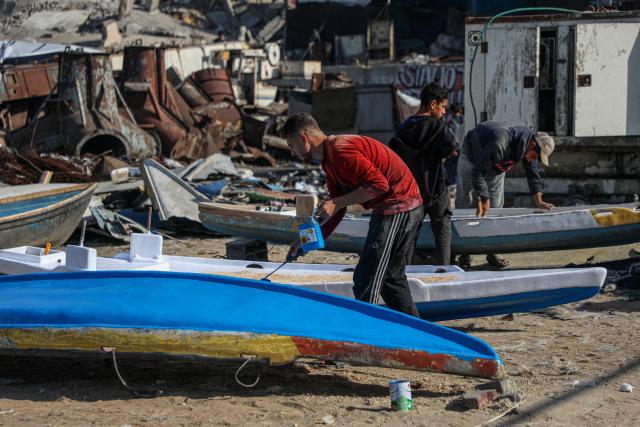 (251127) -- GAZA CITY, Nov. 27, 2025 (Xinhua) -- Palestinians repair a fishing boat destroyed during the Israeli war on the Gaza Strip, inside the seaport in west of Gaza City, on Nov. 27, 2025. (Photo by Rizek Abdeljawad/Xinhua)