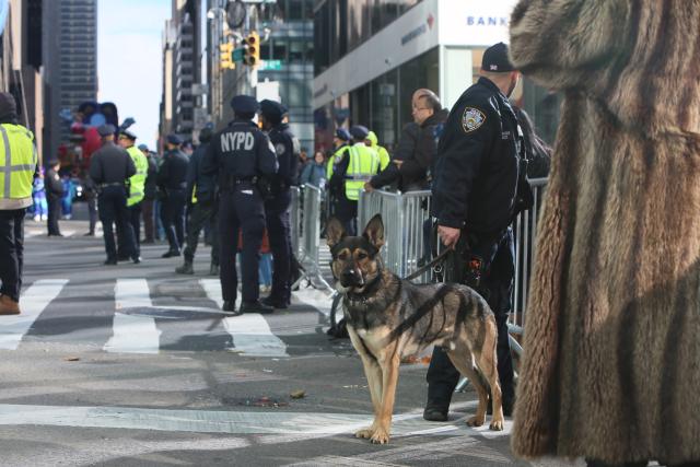 (251127) -- NEW YORK, Nov. 27, 2025 (Xinhua) -- A police officer patrols with a police dog during the Macy´s Thanksgiving Day Parade in New York, the United States, on Nov. 27, 2025. New York City boosted security during the Macy´s Thanksgiving Day Parade on Thursday. (Xinhua/Zhang Fengguo)