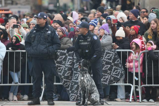 (251127) -- NEW YORK, Nov. 27, 2025 (Xinhua) -- A police officer patrols with a police dog during the Macy´s Thanksgiving Day Parade in New York, the United States, on Nov. 27, 2025. New York City boosted security during the Macy´s Thanksgiving Day Parade on Thursday. (Xinhua/Zhang Fengguo)