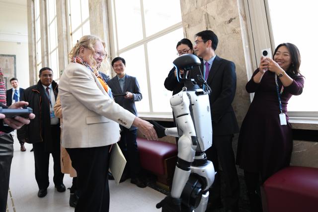 (251128) -- BEIJING, Nov. 28, 2025 (Xinhua) -- Tatiana Valovaya (front), director-general of the United Nations Office at Geneva, shakes hands with a robot before a high-level dialogue on AI governance entitled "Geneva Dialogue: Solidarity for AI Governance" at the Palais des Nations in Geneva, Switzerland, Nov. 25, 2025. The Permanent Mission of China in Geneva, together with the permanent missions of Pakistan and Zambia, has convened a high-level dialogue on AI governance entitled "Geneva Dialogue: Solidarity for AI Governance" at the Palais des Nations, home to the United Nations Office at Geneva, on Tuesday. (Xinhua/Lian Yi)