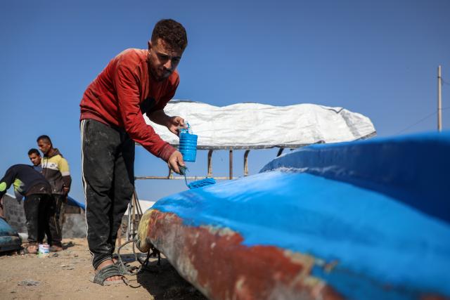 (251128) -- BEIJING, Nov. 28, 2025 (Xinhua) -- A Palestinian repairs a fishing boat destroyed during the Israeli war on the Gaza Strip, inside the seaport in west of Gaza City, on Nov. 27, 2025. (Photo by Rizek Abdeljawad/Xinhua)