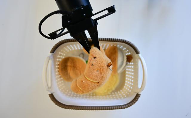 (251128) -- BEIJING, Nov. 28, 2025 (Xinhua) -- A humanoid robot, operated by a staff member for data collection purpose, fetches objects at Zerith, a robotics company, in Hefei, east China's Anhui Province, Nov. 25, 2025. (Xinhua/Zhou Mu)