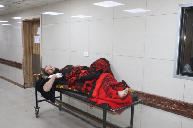 (251128) -- DAMASCUS, Nov. 28, 2025 (Xinhua) -- A man wounded in Israeli airstrikes rests on a stretcher at al-Mouwasat Hospital in Damascus, Syria, Nov. 28, 2025. Israeli airstrikes early Friday killed at least 10 people, including women and children, in the town of Beit Jinn in the southwestern countryside of Damascus, following reported clashes between Israeli troops and local residents, Syrian state media said. (Photo by Monsef Memari/Xinhua)