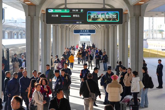 (251128) -- GUIYANG, Nov. 28, 2025 (Xinhua) -- Passengers wait to board the G5356 train, the first train of the Panzhou-Xingyi high-speed railway, at Xingyi South Railway Station in Xingyi, southwest China's Guizhou Province, Nov. 28, 2025. With a design speed of 250 kilometers per hour, the 99-kilometer-long Panzhou-Xingyi high-speed railway officially opened to traffic on Friday, which will further enhance regional transportation networks and promote local economic development. (Photo by Long Jianrui/Xinhua)
