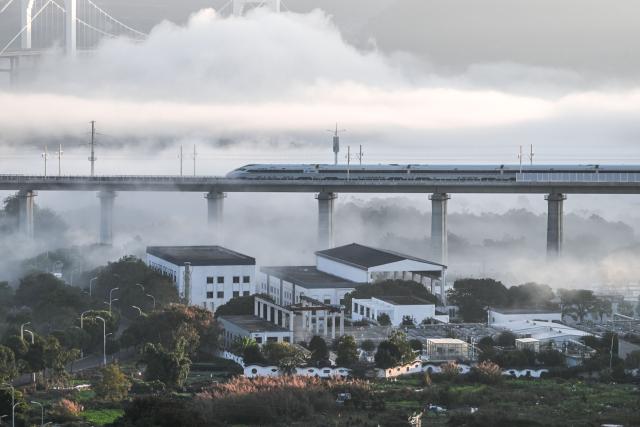 (251128) -- GUIYANG, Nov. 28, 2025 (Xinhua) -- A bullet train runs on a grand bridge of the Panzhou-Xingyi high-speed railway in Xingyi, southwest China's Guizhou Province, Nov. 28, 2025. With a design speed of 250 kilometers per hour, the 99-kilometer-long Panzhou-Xingyi high-speed railway officially opened to traffic on Friday, which will further enhance regional transportation networks and promote local economic development. (Xinhua/Yang Wenbin)