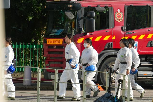(251128) -- HONG KONG, Nov. 28, 2025 (Xinhua) -- Members of the Disaster Victims Identification Unit enter Wang Fuk Court in Tai Po, Hong Kong, south China, Nov. 28, 2025. Hong Kong Police Force will conduct full evidence collection and investigation into the Wang Fuk Court fire in Tai Po, which is expected to take three to four weeks, Chris Tang Ping-keung, secretary for security of the Hong Kong Special Administrative Region government, told a press conference on Friday. (Xinhua/Zhu Wei)