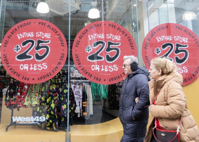 (251129) -- TORONTO, Nov. 29, 2025 (Xinhua) -- People walk past a promotion sign of a shop during Black Friday sales event in Toronto, Canada, Nov. 28, 2025. (Photo by Zou Zheng/Xinhua)