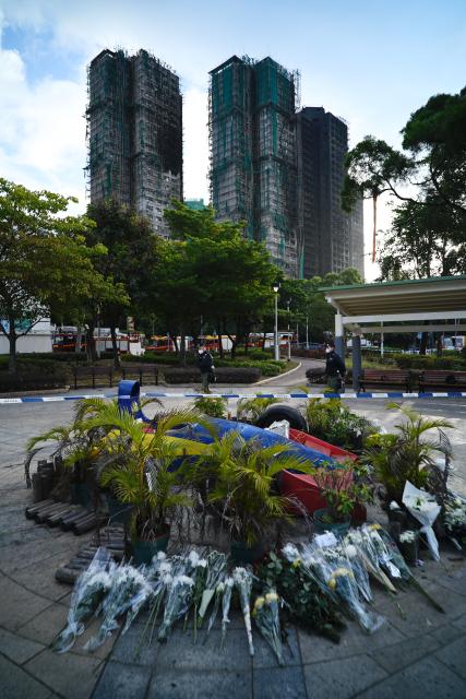 (251129) -- HONG KONG, Nov. 29, 2025 (Xinhua) -- This photo taken on Nov. 29, 2025 shows flowers placed near the site of the residential building fire to mourn the victims in Tai Po of Hong Kong, south China. (Xinhua/Wang Shen)