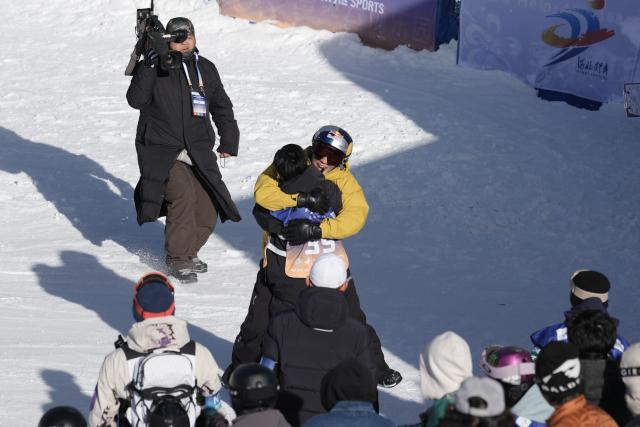 (251129) -- ZHANGJIAKOU, Nov. 29, 2025 (Xinhua) -- Gold medalist Su Yiming (center R) of China and silver medalist Ge Chunyu of China hug each other after the men's final of the FIS Snowboard Big Air World Cup 2026 at Secret Garden in Zhangjiakou, north China's Hebei Province, Nov. 29, 2025. (Xinhua/Lu Xingji)