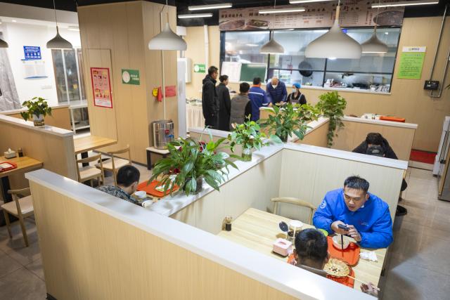 (251129) -- XIONG'AN, Nov. 29, 2025 (Xinhua) -- People have meals at a canteen in Chunmingbei community in Xiong'an New Area, north China's Hebei Province, Nov. 25, 2025. The Xiong'an New Area, designed to relieve Beijing of its non-essential functions, has been leveraging smart and considerate public services to facilitate daily life of relocated residents.
   At Wenhua community in the startup section of Xiong'an New Area, an AI-powered canteen serves as a vivid example of how emerging consumption scenarios makes people feel better with their lives.
   At the canteen, automatic settlement system quickly verifies a customer's identity through facial recognition technology, and associates the food tray with his or her personal information to ensure a seamless payment process. Moreover, the serving zone inside the canteen also has smart devices capable of body weighing, calorie intake-tracking, detailed health status reporting as well as personalized dietary suggestions.
   The Chunmingbei community canteen in Rongdong District of the Xiong'an New Area, for its part, helps ease the burden on working parents by providing affordable dinners for their school-attending children. Nanwenying community canteen, also in Rongdong, offers tiered discounts to senior diners of 60 and above on their meals.
    Besides community canteens, community book stores and supermarkets further add to the convenience of local residents. Xiong'an New Area is building a well-managed and friendly community through meticulous public services. (Xinhua/Wu Zhizun)