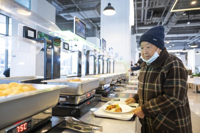 (251129) -- XIONG'AN, Nov. 29, 2025 (Xinhua) -- A senior resident chooses food at an AI-powered canteen in Wenhua community in Xiong'an New Area, north China's Hebei Province, Nov. 25, 2025. The Xiong'an New Area, designed to relieve Beijing of its non-essential functions, has been leveraging smart and considerate public services to facilitate daily life of relocated residents.
   At Wenhua community in the startup section of Xiong'an New Area, an AI-powered canteen serves as a vivid example of how emerging consumption scenarios makes people feel better with their lives.
   At the canteen, automatic settlement system quickly verifies a customer's identity through facial recognition technology, and associates the food tray with his or her personal information to ensure a seamless payment process. Moreover, the serving zone inside the canteen also has smart devices capable of body weighing, calorie intake-tracking, detailed health status reporting as well as personalized dietary suggestions.
   The Chunmingbei community canteen in Rongdong District of the Xiong'an New Area, for its part, helps ease the burden on working parents by providing affordable dinners for their school-attending children. Nanwenying community canteen, also in Rongdong, offers tiered discounts to senior diners of 60 and above on their meals.
    Besides community canteens, community book stores and supermarkets further add to the convenience of local residents. Xiong'an New Area is building a well-managed and friendly community through meticulous public services. (Xinhua/Wu Zhizun)