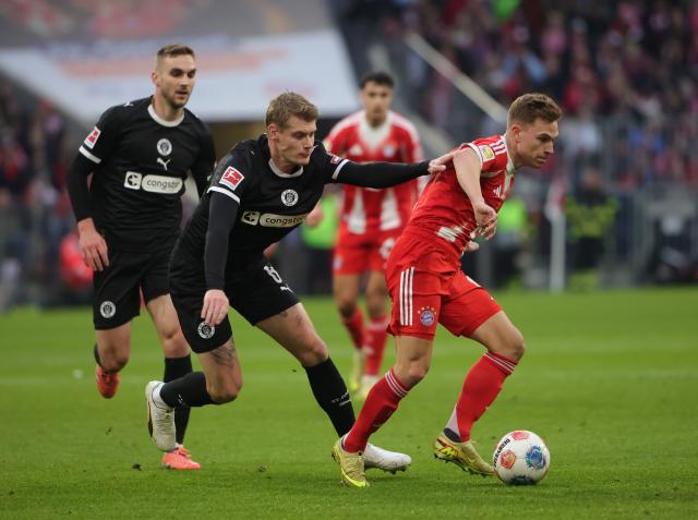 (251130) -- MUNICH, Nov. 30, 2025 (Xinhua) -- Joshua Kimmich (R) of FC Bayern Munich vies with Eric Anders Smith (C) of FC St. Pauli during the German first division Bundesliga football match between FC Bayern Munich and FC St. Pauli in Munich, Germany, Nov. 29, 2025. (Photo by Philippe Ruiz/Xinhua)