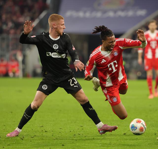 (251130) -- MUNICH, Nov. 30, 2025 (Xinhua) -- Michael Olise (R) of FC Bayern Munich vies with Louis Oppie of FC St. Pauli during the German first division Bundesliga football match between FC Bayern Munich and FC St. Pauli in Munich, Germany, Nov. 29, 2025. (Photo by Philippe Ruiz/Xinhua)