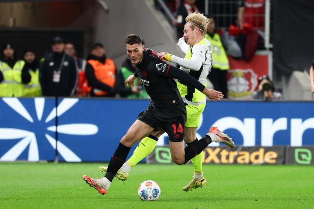 (251130) -- LEVERKUSEN, Nov. 30, 2025 (Xinhua) -- Patrik Schick (L) of Bayer 04 Leverkusen vies with Julian Brandt of Borussia Dortmund during the German first division of Bundesliga football match between Bayer 04 Leverkusen and Borussia Dortmund in Leverkusen, Germany, Nov. 29. 2025. (Photo by Joachim Bywaletz/Xinhua)
