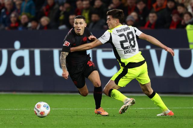 (251130) -- LEVERKUSEN, Nov. 30, 2025 (Xinhua) -- Alejandro Grimaldo (L) of Bayer 04 Leverkusen vies with Aaron Anselmino of Borussia Dortmund during the German first division of Bundesliga football match between Bayer 04 Leverkusen and Borussia Dortmund in Leverkusen, Germany, Nov. 29. 2025. (Photo by Joachim Bywaletz/Xinhua)
