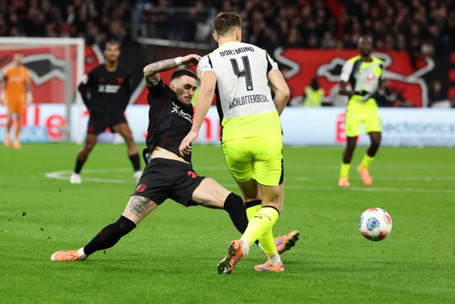 (251130) -- LEVERKUSEN, Nov. 30, 2025 (Xinhua) -- Aleix Garcia (L) of Bayer 04 Leverkusen vies with Nico Schlotterbeck of Borussia Dortmund during the German first division of Bundesliga football match between Bayer 04 Leverkusen and Borussia Dortmund in Leverkusen, Germany, Nov. 29. 2025. (Photo by Joachim Bywaletz/Xinhua)