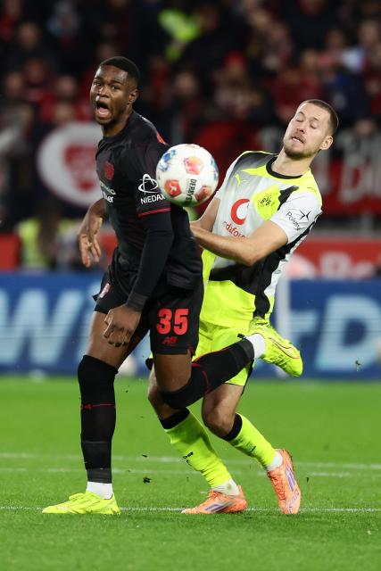 (251130) -- LEVERKUSEN, Nov. 30, 2025 (Xinhua) -- Christian Kofane (L) of Bayer 04 Leverkusen vies with Waldemar Anton of Borussia Dortmund during the German first division of Bundesliga football match between Bayer 04 Leverkusen and Borussia Dortmund in Leverkusen, Germany, Nov. 29. 2025. (Photo by Joachim Bywaletz/Xinhua)