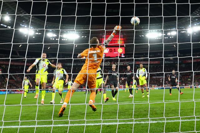 (251130) -- LEVERKUSEN, Nov. 30, 2025 (Xinhua) -- Mark Flekken  (front), goalkeeper of Bayer 04 Leverkusen, makes a save during the German first division of Bundesliga football match between Bayer 04 Leverkusen and Borussia Dortmund in Leverkusen, Germany, Nov. 29. 2025. (Photo by Joachim Bywaletz/Xinhua)