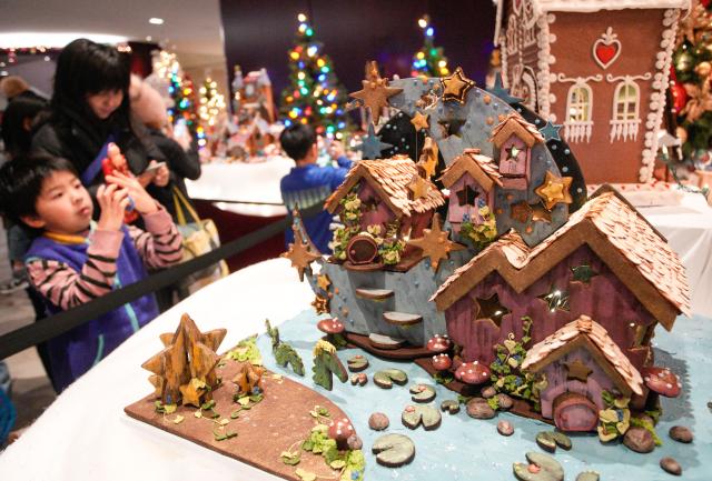 (251130) -- VANCOUVER, Nov. 30, 2025 (Xinhua) -- People look at gingerbread house creations during the annual "Gingerbread Lane" event in Vancouver, British Columbia, Canada, Nov. 29, 2025. Canada's longest-running gingerbread house display event returned for its 33rd year, featuring more than 30 gingerbread houses and inviting the public to vote for their favourite creations crafted by professional bakers, culinary artists, and culinary school students. (Photo by Liang Sen/Xinhua)