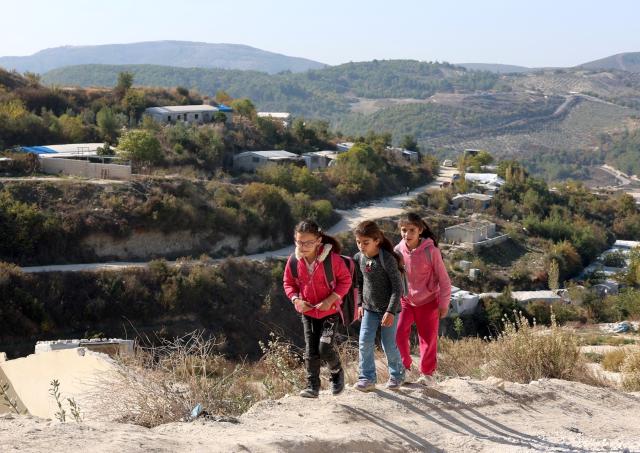 (251130) -- KHIRBET AL-JOZ, Nov. 30, 2025 (Xinhua) -- Girls walk up a hillside path overlooking the makeshift displacement camps in Khirbet al-Joz of northwestern Idlib province, Syria, Nov. 20, 2025.
  TO GO WITH "Feature: Stuck in tents and cut off from aid, displaced Syrians in NW border camp face another hard winter" (Str/Xinhua)