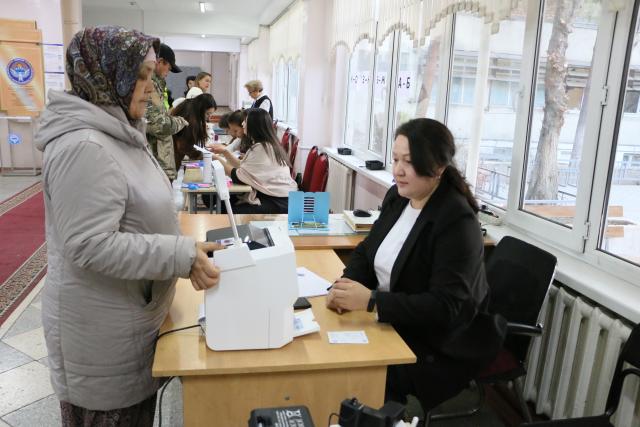 (251130) -- BISHKEK, Nov. 30, 2025 (Xinhua) -- A voter has her identity verified at a polling station in Bishkek, Kyrgyzstan, on Nov. 30, 2025. Early parliamentary elections began in Kyrgyzstan on Sunday to elect 90 deputies to the country's unicameral legislature. (Xinhua/Jiang Youlin)