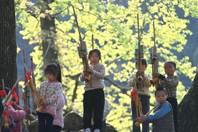 (251130) -- NANNING, Nov. 30, 2025 (Xinhua) -- Pupils play Lusheng, a traditional reed-pipe wind instrument, during a school activity in Rongshui Miao Autonomous County, south China's Guangxi Zhuang Autonomous Region, March 28, 2025. Rongshui County has leveraged its unique cultural resources of Lusheng to strengthen the inheritance of Miao ethnic culture and empower rural revitalization. (Xinhua/Huang Xiaobang)